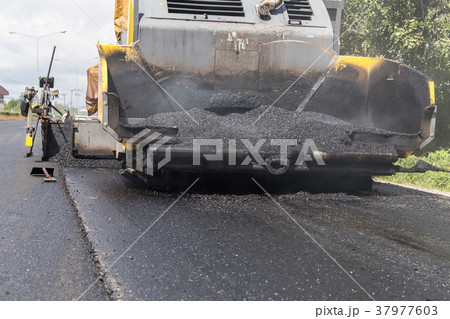 Worker operating the process of building new asphalt road on the new road construction site in Thailand Worker operating the process of building new asphalt road on the new road construction site in Thailand 37977603