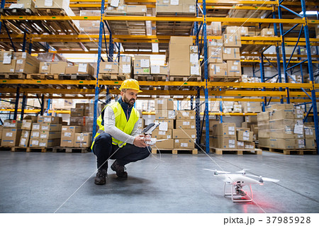 Man with drone in a warehouse. 37985928