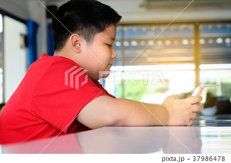 Asian child Boy are addictive playing tablet Asian child Boy are addictive playing tablet 37986478