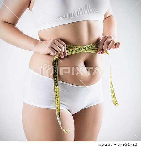 Overweight woman measuring her fat belly. 37991723