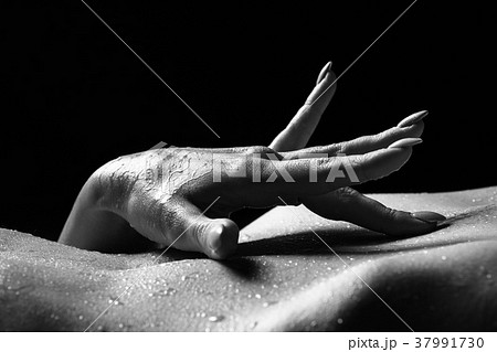 Close-up view of woman's hand touching her belly. Close-up view of woman's hand touching her belly. 37991730