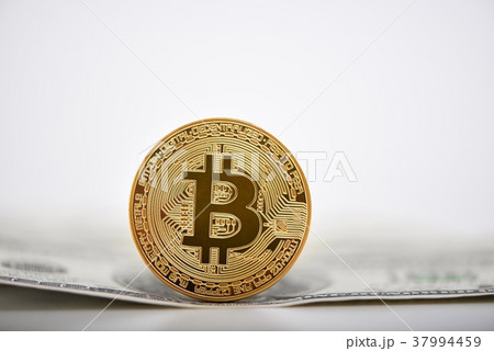 Golden bitcoin presented on a dollar banknote as 37994459