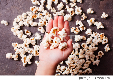 Children's hand holds popcorn  37996170