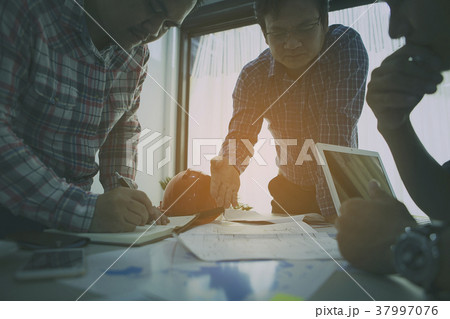 Businessmen and engineers are planning a project. 37997076