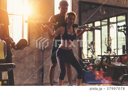 Portrait pretty girl training in gym with trainer 37997078