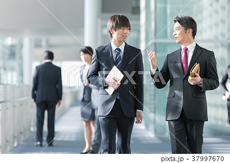 会話をするビジネスマン スーツ姿の男性 ビジネスイメージの写真素材