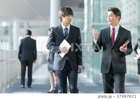 会話をするビジネスマン スーツ姿の男性 ビジネスイメージの写真素材