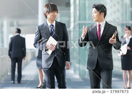会話をするビジネスマン スーツ姿の男性 ビジネスイメージの写真素材 