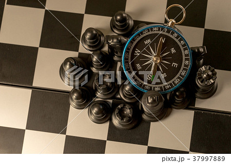 Chess and navigation compass on chessboard in conc Chess and navigation compass on chessboard in conc 37997889