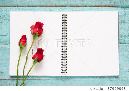 Red rose flowers and blank notebook. 37999043