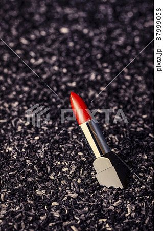 Red lipstick, on a black charcoal background 37999058