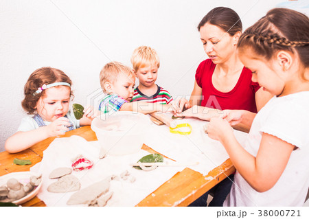 Happy children are engaged with modeling clay 38000721