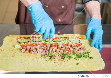 Cook prepares a shawarma. Cook prepares a shawarma. 38002999