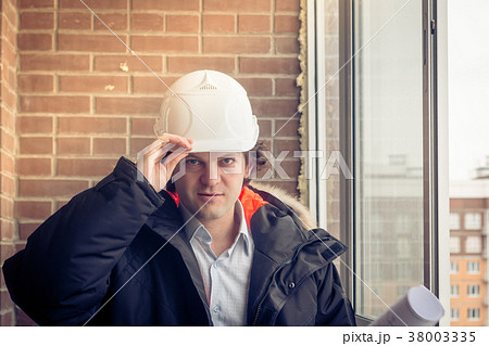 Smiling business engineer with white safety helmet Smiling business engineer with white safety helmet 38003335