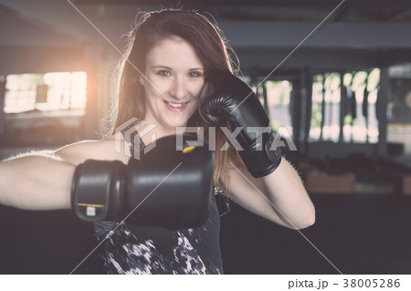 Young caucasian woman doing exercise with Thai boxing (Muay Thai) equipment in gym. Health and fitness concept. Young caucasian woman doing exercise with Thai boxing (Muay Thai) equipment in gym. Health and fitness concept. 38005286