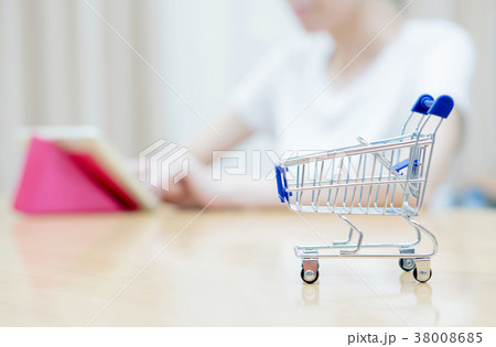 Woman shopping at the desk with miniature trolley Woman shopping at the desk with miniature trolley 38008685