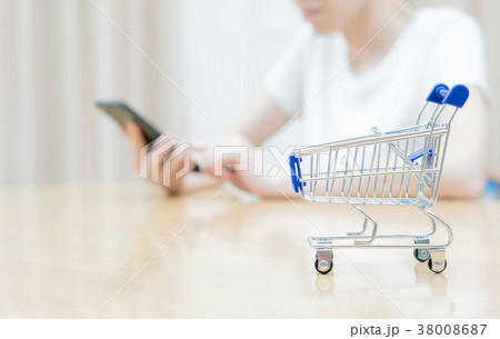 Woman shopping at the desk with miniature trolley 38008687