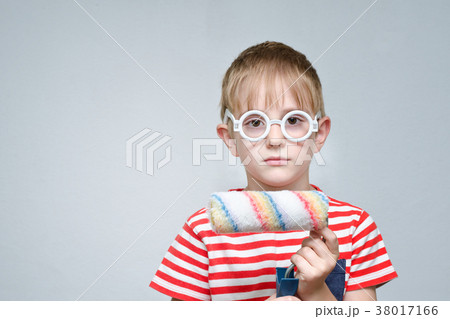 Serious boy in glasses with a roller for coloring 38017166
