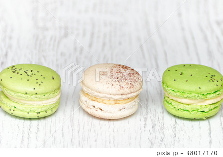 Three macarons on a light wooden table. Close up 38017170