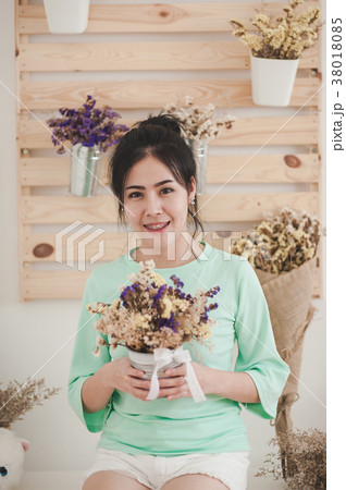 Young woman with flowers in her hand 38018085