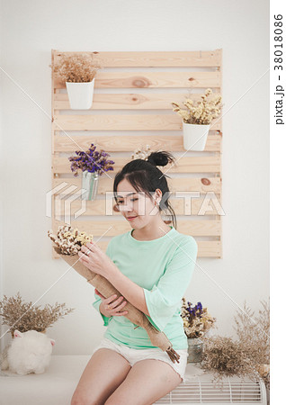 Young woman with flowers in her hand 38018086