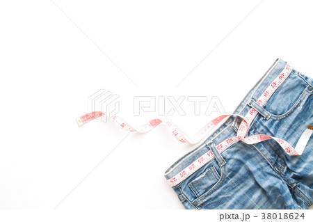 Flat lay of woman blue jeans with measuring-tape 38018624