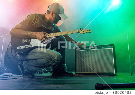 The guitarist tunes the combo amplifier. 38020482