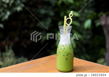 Cool green milk in a glass bottle on a  table. 38025604