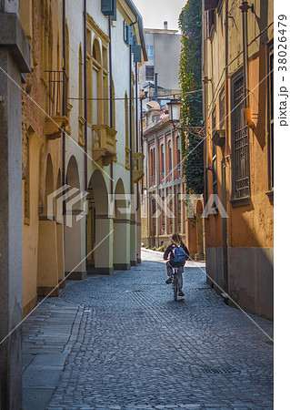 A teen on bicycle is riding along the old streets  38026479