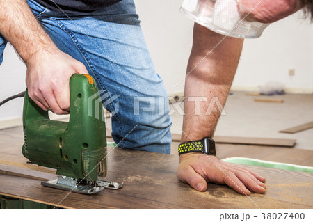 DIY worker cutting wooden panel with jig saw DIY worker cutting wooden panel with jig saw 38027400