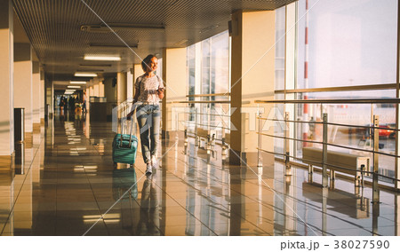 young woman goes  at airport at window with suitcase waiting for 38027590