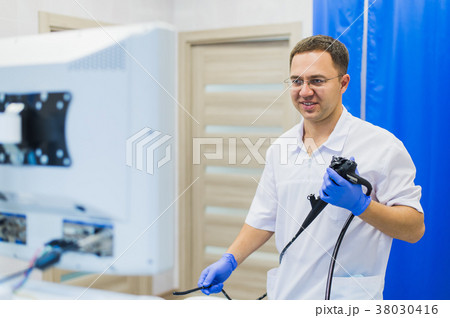 proctologist doctor holding Ligador hemorroidal in 38030416