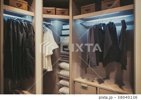 Black and white cloths hanging in wooden wardrobe at home 38040136