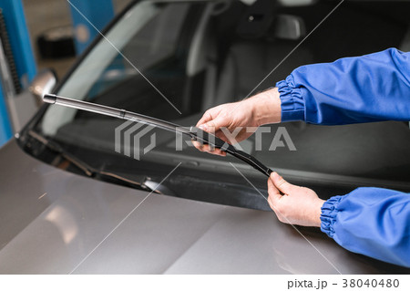 Technician is changing windscreen wipers on a car 38040480