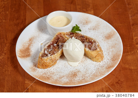 Apple strudel with ice cream scoop on plate Apple strudel with ice cream scoop on plate 38040784