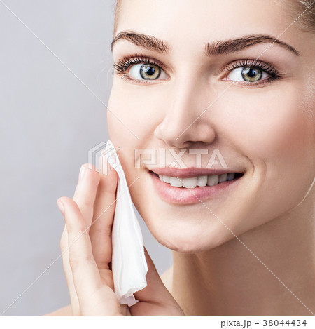 Young woman cleaning her face by napkins. 38044434