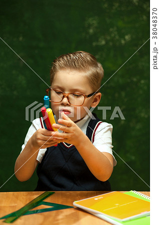 Positive cute little boy posing at school desk 38048370