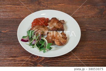 Roasted pork neck on a plate.  38053075
