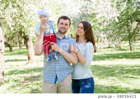 young happy family walking outdoor. Parents hold young happy family walking outdoor. Parents hold 38056425