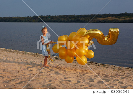 Little girl with many golden balloons on the beach 38056545
