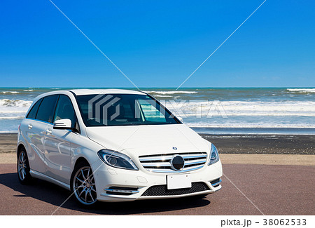 真夏のドライブイメージ 白い車と海と青空 の写真素材