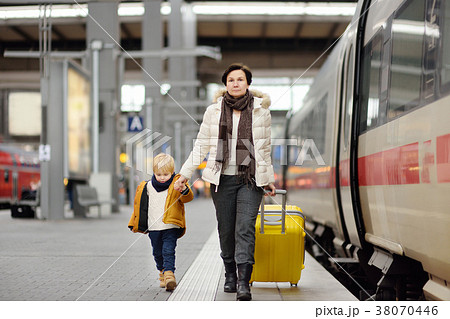 Cute little boy and his grandmother/mother waiting express train on railway station platform Cute little boy and his grandmother/mother waiting express train on railway station platform 38070446