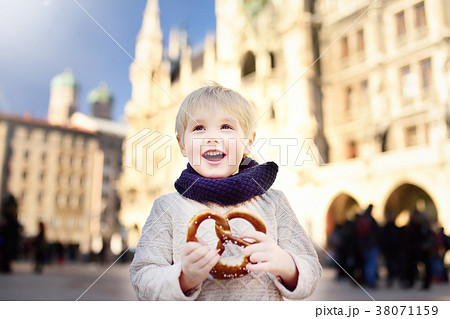 Little tourist holding traditional bavarian bread Little tourist holding traditional bavarian bread 38071159