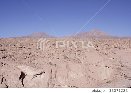 初夏の南米チリ北部、アタカマ高地に広がる荒涼とした岩に覆われた平原とアンデス山脈の絶景 38071228