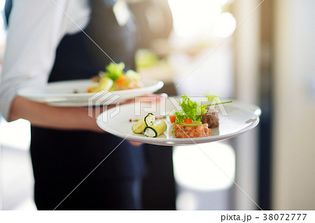 Waiter carrying plates with meat dish on some festive event Waiter carrying plates with meat dish on some festive event 38072777