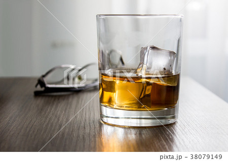 Glass of whiskey, brandy, cognac with ice cubes on 38079149