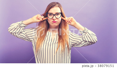 Young woman blocking her ears Young woman blocking her ears 38079151