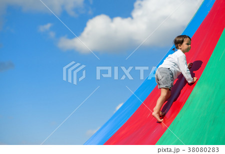 Little girl goes up on rainbow, at playground 38080283
