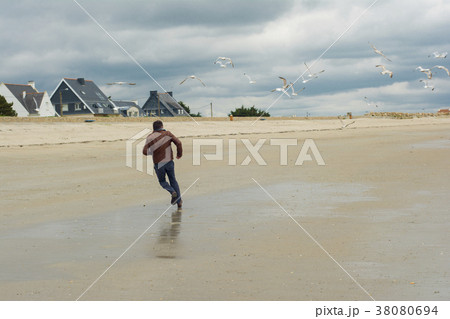 The man runs away. Group of seagull birds. 38080694