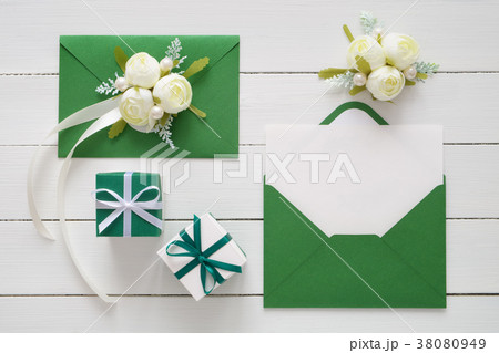 Invitation cards in green envelopes, gift boxes. 38080949